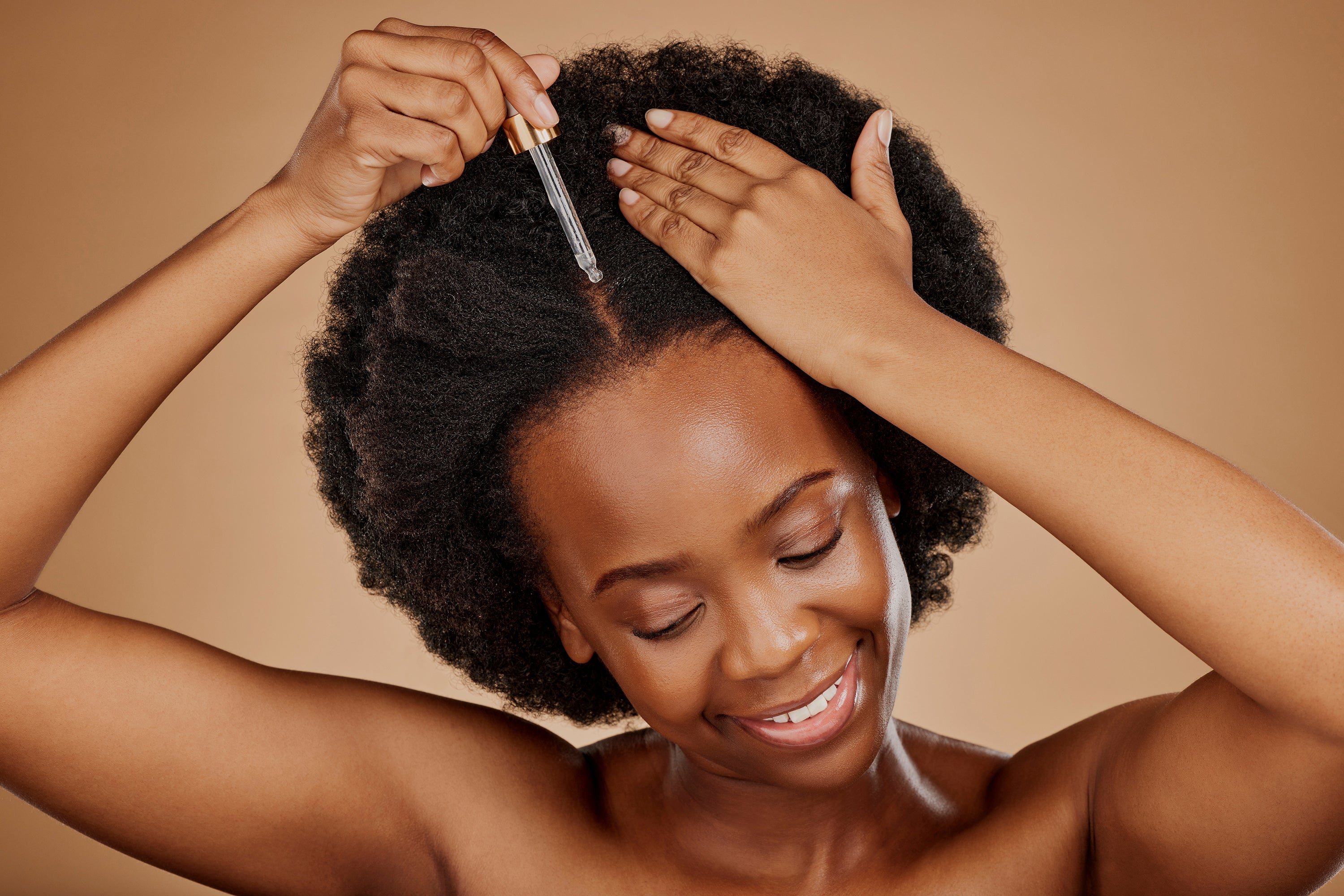 Girl using dropper on her scalp.